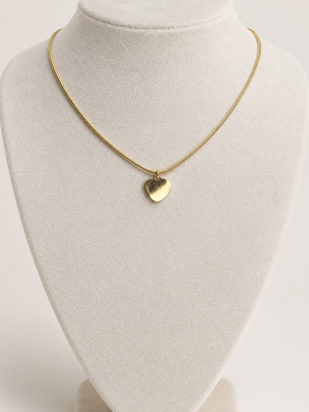 Amalya, collier doré à petit pendentif cœur sur fond beige – OZ’anges