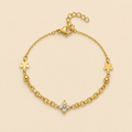 Bracelet Éloria doré avec fleur à quatre cristaux sur fond ivoire
