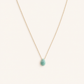 Naïa, collier doré à pendentif goutte turquoise sur fond beige ivoire