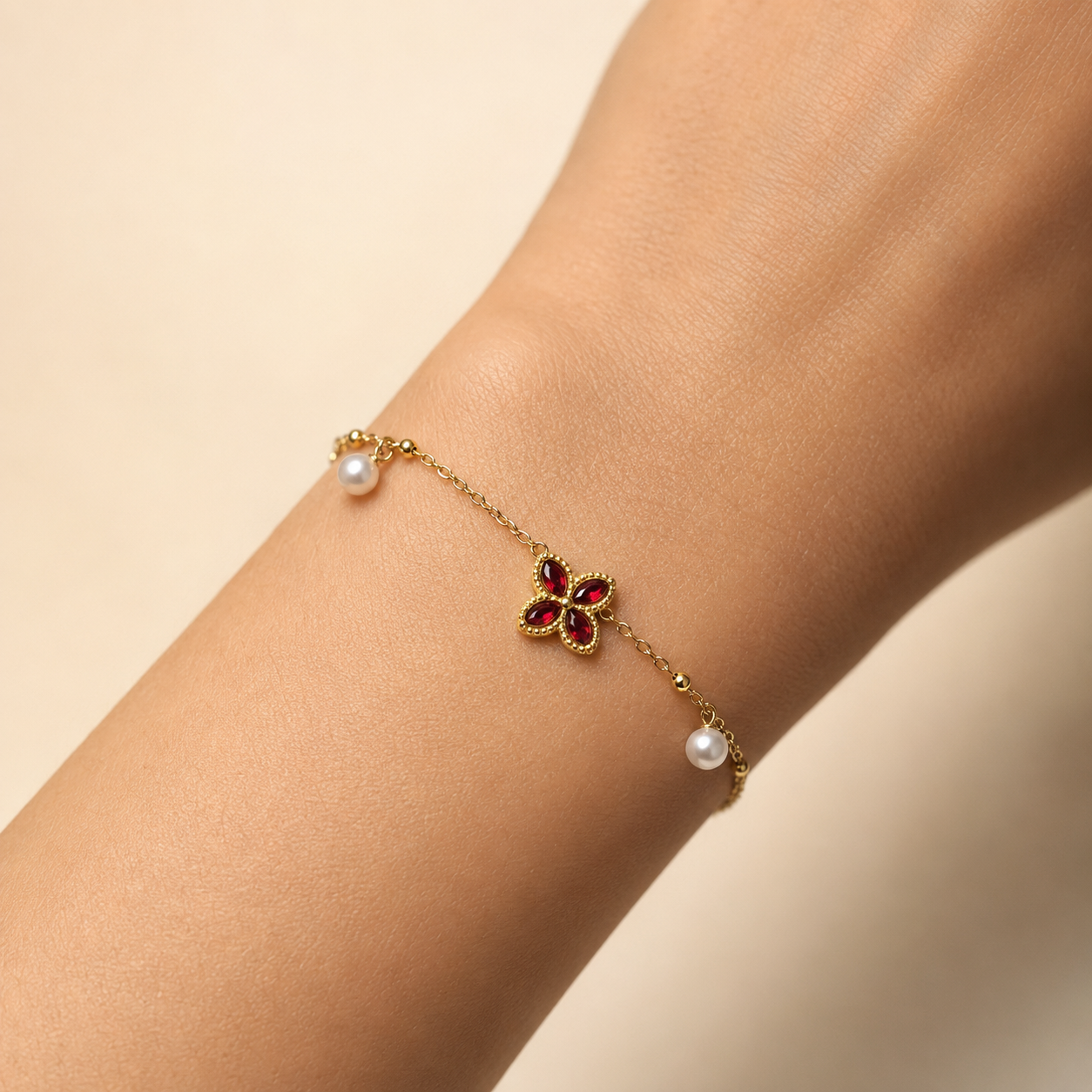 Nélaya bracelet trèfle doré perlé, variante rouge rubis, porté au poignet – OZ’anges