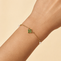 Nélaya bracelet trèfle doré perlé, variante vert émeraude, porté au poignet – OZ’anges