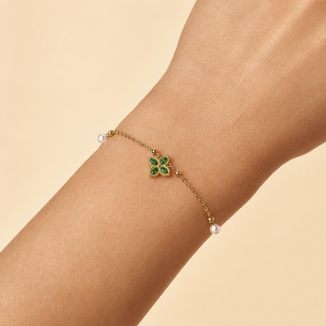 Nélaya bracelet trèfle doré perlé, variante vert émeraude, porté au poignet – OZ’anges
