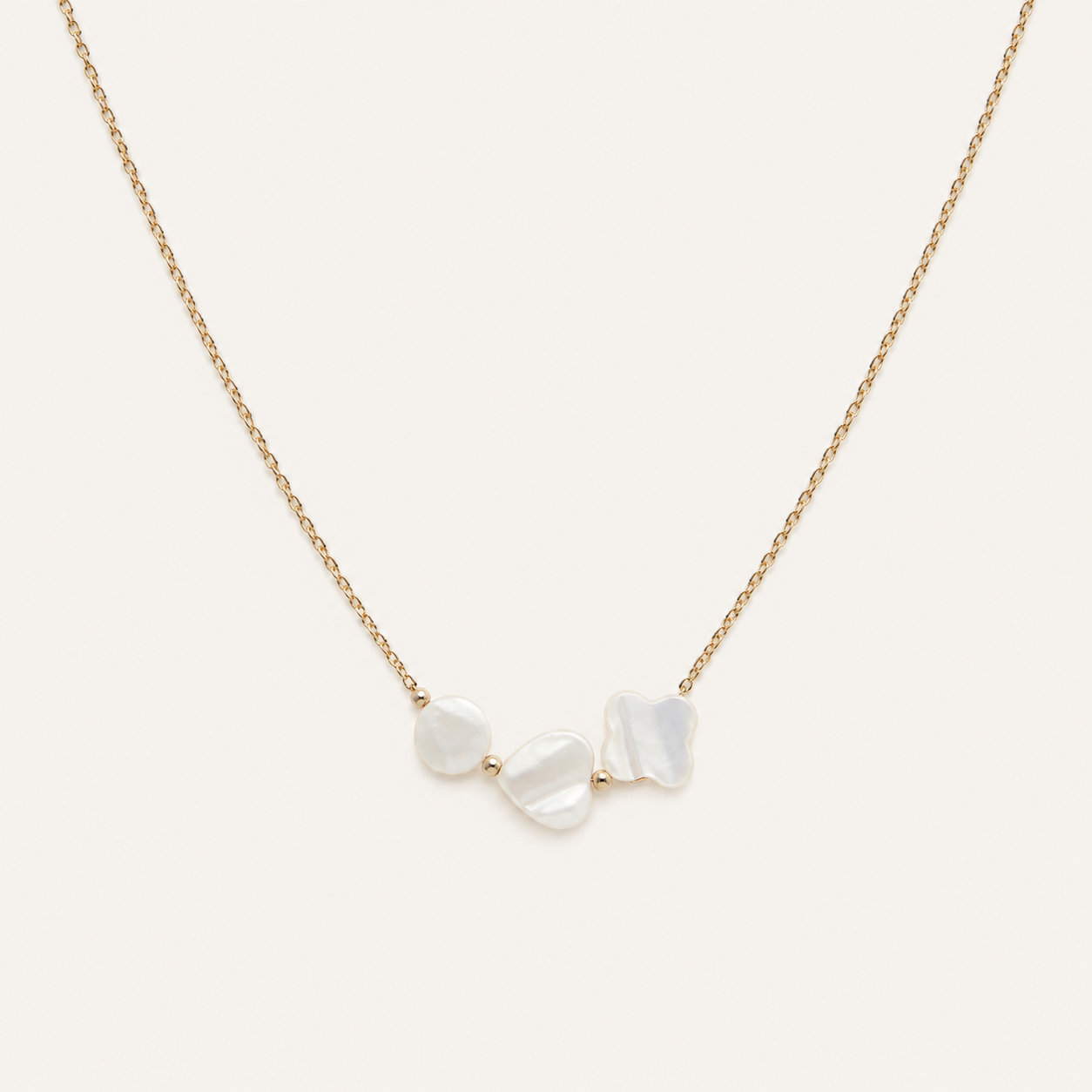 Nouréa, collier doré aux motifs nacrés sur fond beige ivoire